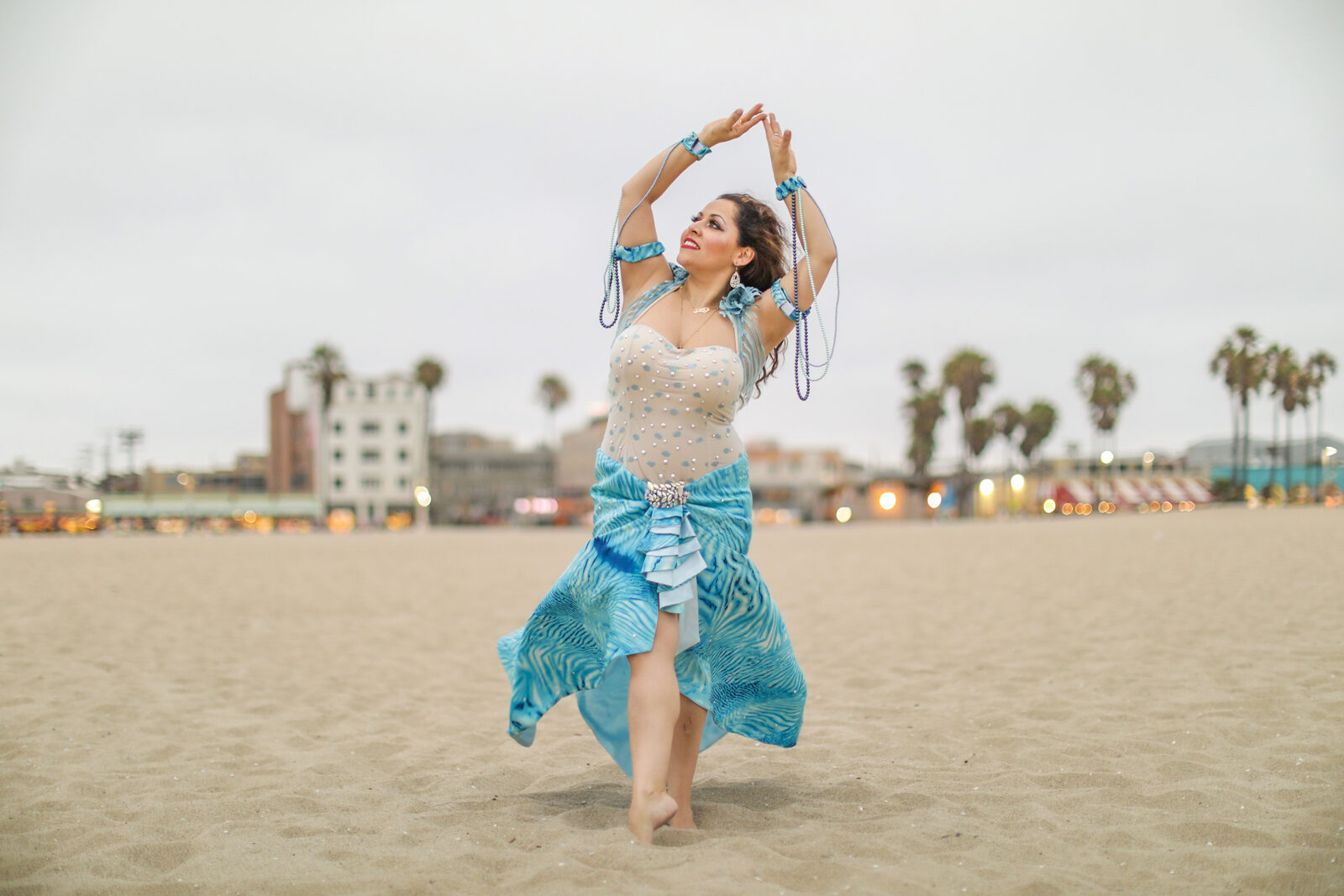 Jrisi dancing on the beach in a blue costume