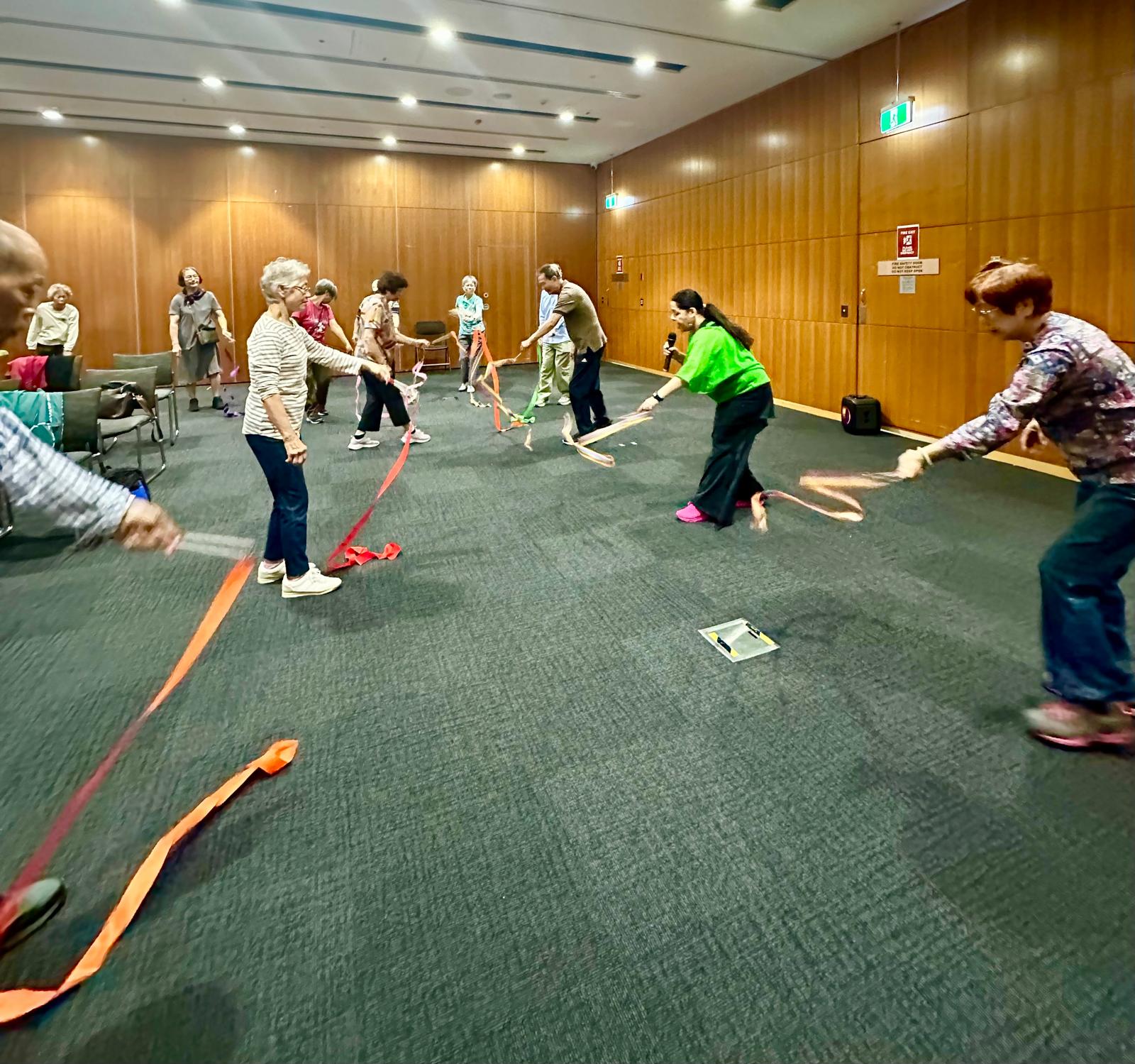 Seniors movement therapy class using ribbons